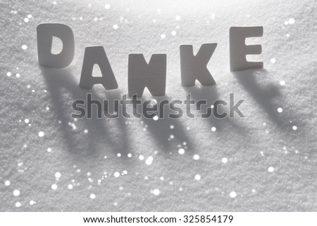 White Letters Building German Text Danke Means Thank You On White Snow. Snowy Landscape Or Scenery With Snowflakes. Christmas Card For Seasons Greetings Or Usable As Background.