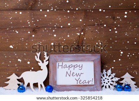 Blue Christmas Decoration On Snow. Christmas Balls, Snowflakes, Reindeer And Tree. Christmas Card With Picture Frame With English Text Happy New Year. Rustic, Vintage Brown Wooden Background. 