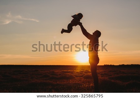 Father and child on sunset