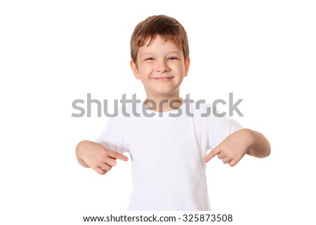 Happy little boy pointing his fingers on a blank t-shirt, a place for your advertising.