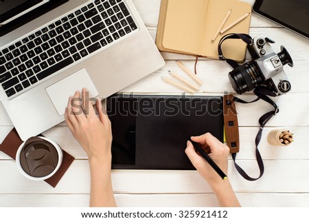 Graphic designer using graphic tablet in digital work and photo editing, view from above. Creative workplace in office