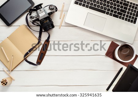 Working table of photographer or artist overhead view, wooden surface with free space