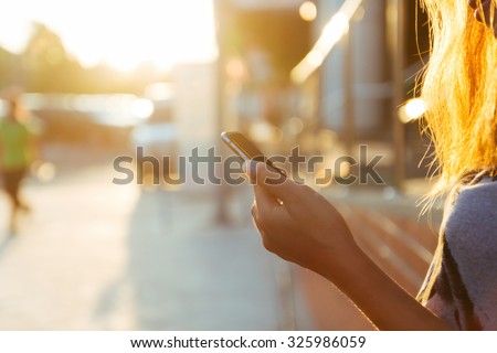closeup women using smartphone at sunset