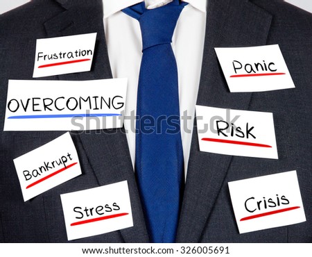 Photo of business suit and tie with OVERCOMING concept paper cards