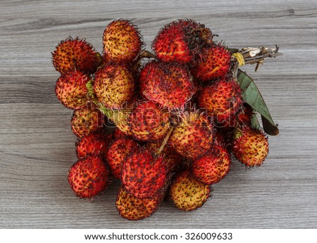 Asian fruit - rambutan - on the wood background