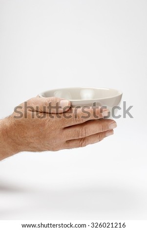 Hungry man holding empty bowl