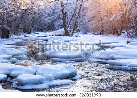 Winter landscape by a river in the sunset Royalty-Free Stock Photo #326021993