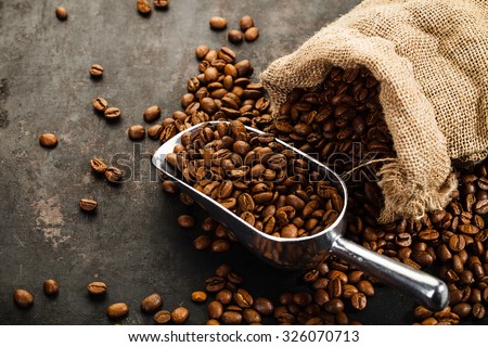Cup of coffee, bag and scoop on old rusty background Royalty-Free Stock Photo #326070713