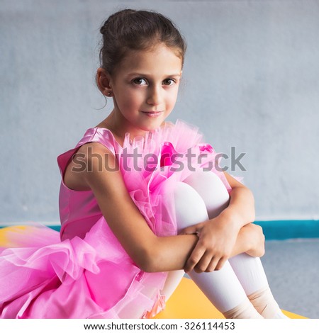 beautiful little ballerina in pink dress in dance class