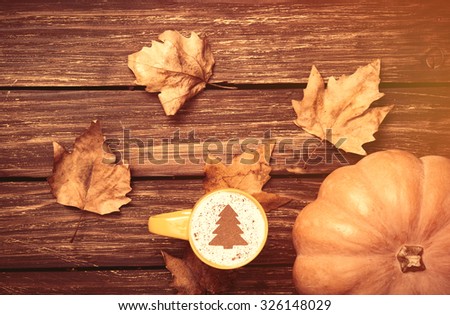 Cup of cappuccino and pumpkin on wooden table 