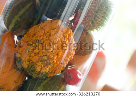 Decorative pumpkins in glass pot 