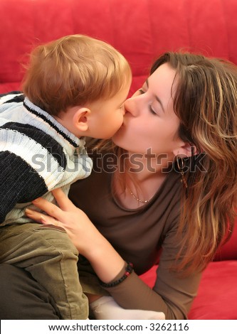 Little blond baby boy kissing her mother