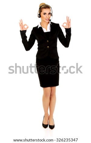 Happy businesswoman shows OK sign.