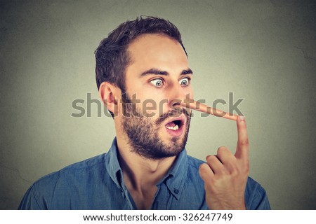 Man with long nose isolated on grey wall background. Liar concept. Human face expressions, emotions, feelings. Royalty-Free Stock Photo #326247749