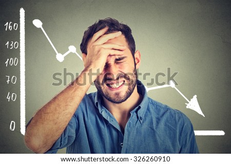 Portrait frustrated stressed young man desperate with financial market chart graphic going down on grey office wall background. Poor economy financial crisis concept. Face expression, emotion
 Royalty-Free Stock Photo #326260910