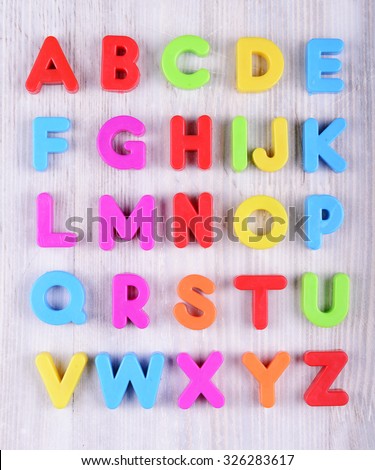 colorful plastic English alphabet on a white wooden background