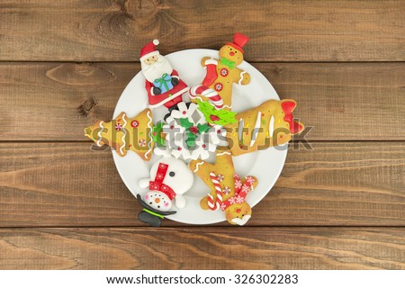 wood on a white plate background Christmas tree cookies, santa, middle-aged man, snowman, snowflake, candy. New year food