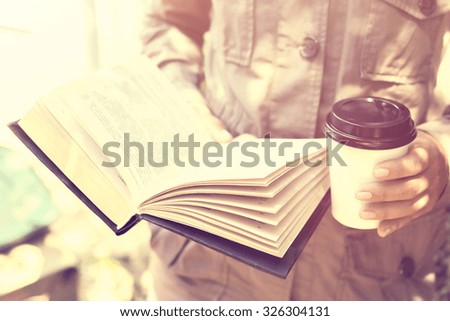 Girl reading a book and drinking coffee, vintage photo effect