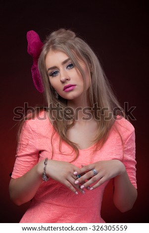 Close-up portrait, isolated, Blonde model looks like Barbie with pink lips and blue eyes with pink bow 