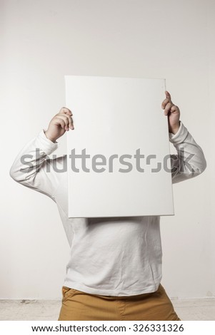 A asian(japan, chinese, korea) pretty boy(kid, children) hold a white(blink, empty) canvas frame with a smile isolated white at the studio.