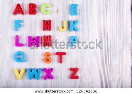 colorful plastic English alphabet on a white wooden background