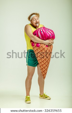 Funny picture of red haired, bearded, plump man on white background.  Man holding a big ice cream 