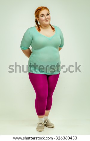 Funny picture of amusing, red haired, chubby woman on white background. Woman is smiling 