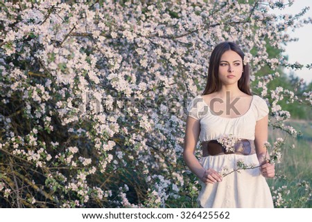 Beautiful young girl on background  flowering  apple-tree