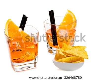 two glasses of spritz aperitif aperol cocktail with orange slices and ice cubes near tacos chips on white background