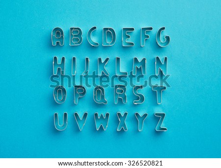 Alphabet letters organized over blue background, top view