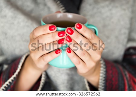 Female hands holding a mug of hot tea Royalty-Free Stock Photo #326572562