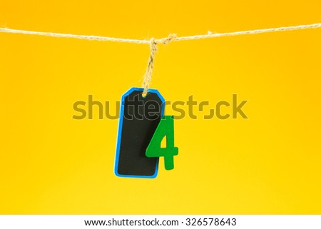 Blank wood label  hanging with clothes pin on clothesline on yel