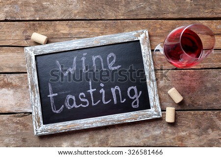 Square frame with wine glass on wooden background