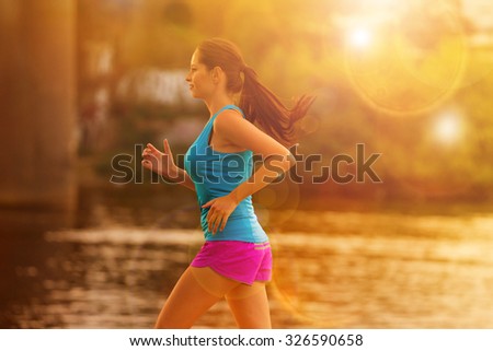 Running woman during sunny day in the city. 