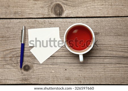 Blank business cards with pen and tea cup on wooden office table