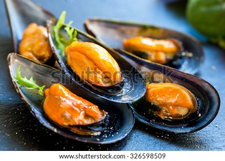 Macro close up of appetizing fresh Steamed sea mussels. Large blue mussels on dark plate Royalty-Free Stock Photo #326598509