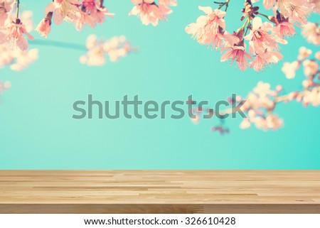 Wood table top on blur pink Sakura flower background, vintage tone - can be used for display or montage your products