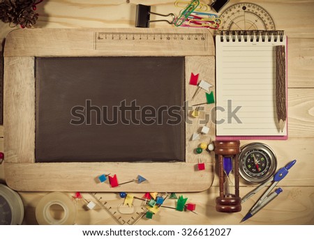 vintage tone image of wooden table top view of the chalk board with creative stationery items to draw, paint. For creative idea work of the artist.