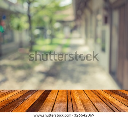 wood floor and vintage tone blur image of Long empty corridor with open space to the green garden with bokeh for background usage.