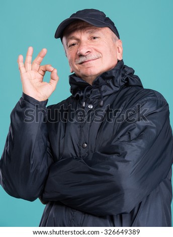 Portrait of senior smiling man on a blue background. Winter concept
