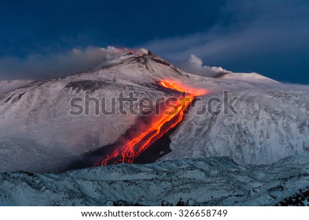 Volcano Etna Eruption - lava flow through the snow Royalty-Free Stock Photo #326658749