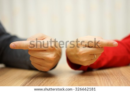 adult couple has difficulties in relationship an both shows the finger at himself and herself Royalty-Free Stock Photo #326662181