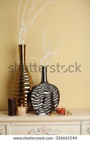 Modern vases with decor on fireplace in room