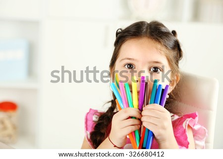 Cute little girl with colorful crayons, close-up