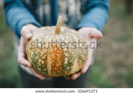 Farmer man holding fresh pumpkin in his hands