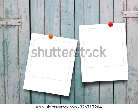 Two square instant photo frames with pins on wooden window shutters