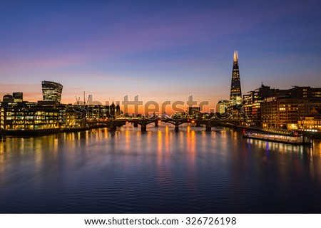 London cityscape during sunrise - river Thames with silhouettes of modern skyscrapers