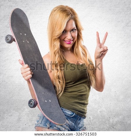 Skateboarder girl doing victory gesture