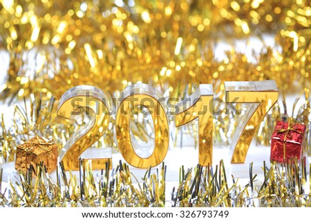 Golden 2017 3d icon with gift box in the christmas ornaments golden tinsel defocused blur backgrounds