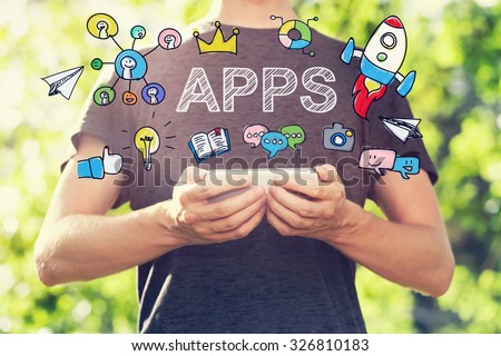 APPS concept with young man holding his smartphone outside in the park toward sunset Royalty-Free Stock Photo #326810183